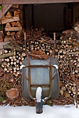 Wheelbarrow leaning against stacked firewood