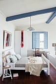 Clean, white bedroom with pastel blue shutters on mezzanine