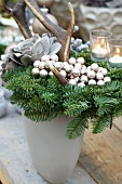 Christmas arrangement of fir branches, antlers, silver baubles and silver rose