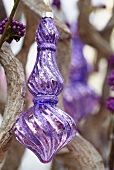 Christmas arrangement of spiral twigs and purple baubles