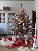 Decorated Christmas tree and presents on floor in rustic living room