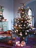 Dekorierter Weihnachtsbaum und Geschenke auf Boden im Wohnraum einer Landhausvilla