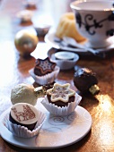 An ornate plate of chocolate treats in paper cases, on a golden table covering