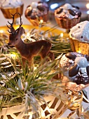 Deer figurine and cake-shaped ornaments in dish with fairy lights
