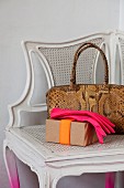 Neon-coloured ladies' gloves and snakeskin handbag on antique corner chair with spray-painted legs