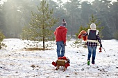 Couple with sledge in woods