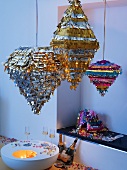 Party lanterns made of metal strips above glasses of champagne on low table and champagne bottles in a drift of confetti