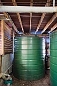 Water storage tanks in technology room of eco house; ceiling and walls made of wooden slats