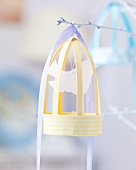Paper bird cage on white twig