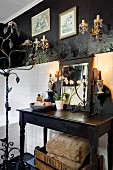 Bathroom with black-painted walls, white wall tiles, wrought iron standard candelabra and black vintage washstand