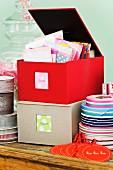 Colourful correspondence cards and ribbons in fabric-covered storage boxes