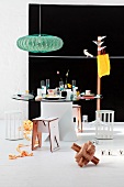 Retro lamp above modern dining table with glass top in front of black mural