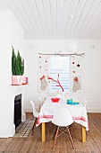 Dining table in front of festively decorated window and shutters