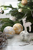 Christmas baubles and reindeer ornament hanging from fir branch