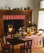 Rustic hearth in open fireplace with wooden surround in traditional kitchen; polenta cooking in pot over open fire