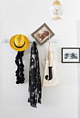 Hat and scarf hanging from wall-mounted coat rack
