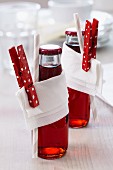 Bottled drinks decorated with napkins & painted clothes pegs