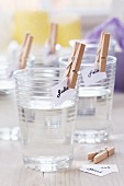 Name tags attached to drinking glasses with clothes pegs