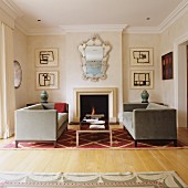 Velvet sofas on star-patterned rug in front of fireplace and ornate, antique mirror and modern artworks on walls