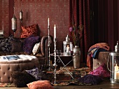 Living room in the Bohemian Look: pillows on the floor and on a leather sofa, upholstered table, side table and silver candlesticks