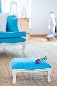 Blauer antiker Armstuhl und Hocker mit Lavendelblüten auf Teppich