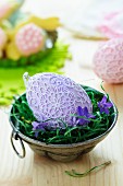 Easter egg decorated with lace doilies and campanula flowers in metal cake mould