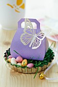 Easter gift in gift box with paper butterfly in Easter nest in tart tin