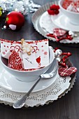Christmas place setting with tart tin as plate charger, napkin and fir-tree clothes peg holding name tag