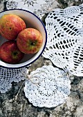Crocheted doilies tied together as mat underneath bowl of apples