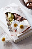 Guest favour of folded newspaper pocket filled with sweets and flowers