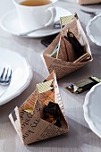 Newspaper boats filled with chocolates as table decorations