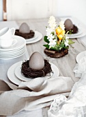 Easter table set with spring flowers, Easter eggs, crockery and napkins