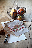 Christmas card decorated with lace paper doily and wire basket of apples