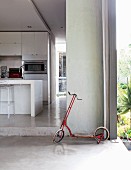 Child's scooter in open doorway leading to kitchen with island counter
