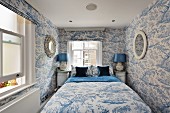 Bedroom in fresh blue and white with toile tree pattern on both wallpaper and textiles