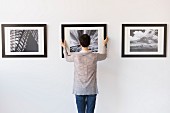 Woman hanging photos in a gallery