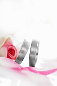 Two wedding rings with a pink rose
