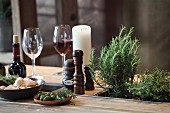 Rustic dining table made from pallet with potted herbs, candles and wine glasses