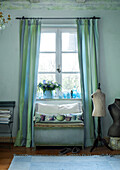 Cozy reading corner with bench by the window and dressmaker's dummy