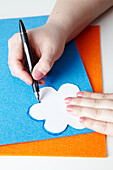 Woman tracing flower motif onto sheet of craft felt