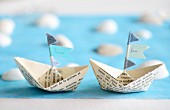 Paper boats with names on flags as place cards