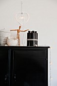Various containers, artists' wooden mannequin and light art objets d'art on black cabinet
