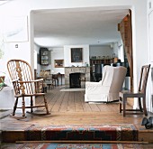 Stufe bis zu einem Landhaus-Wohnzimmer mit Kamin, Holzboden und verschiedene Stühlen