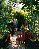 Blick in sommerlichen Garten mit Kiesweg & Gartentürchen aus Holz