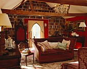 Wohnraum mit Sofa, antiken Möbeln, Teppichen & Bücherwand