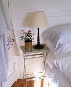 Weisses Schlafzimmer im Landhausstil mit Bett & Beistelltischchen aus Metall