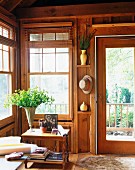 Wohnzimmerecke in gemütlichem Holzhaus und Blick in Garten