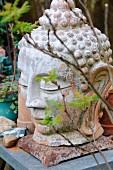 Buddhakopf als Gartendeko auf Gartentisch