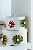 Colourful paper flowers decorating set of white storage boxes