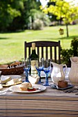 Mit Käse und Wein gedeckter Tisch im Garten